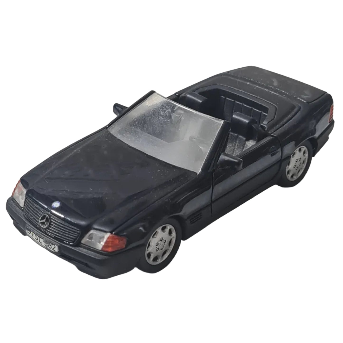 Black toy car on a textured white surface