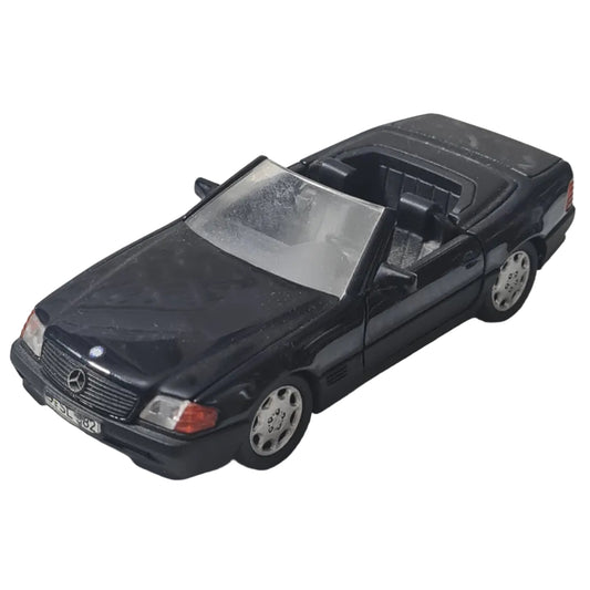 Black toy car on a textured white surface