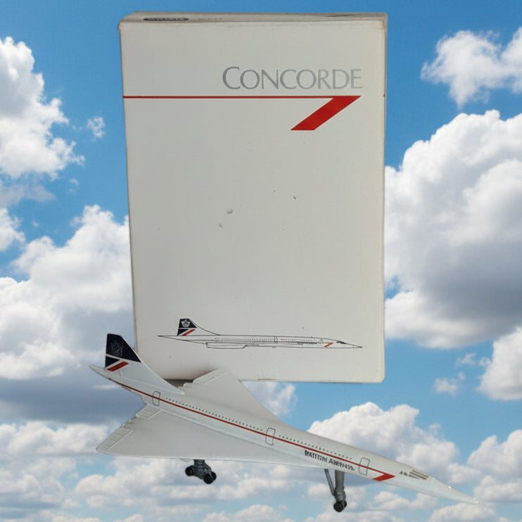 A white Concorde model airplane with red and blue accents is shown leaning against a white wall next to its white branded box.