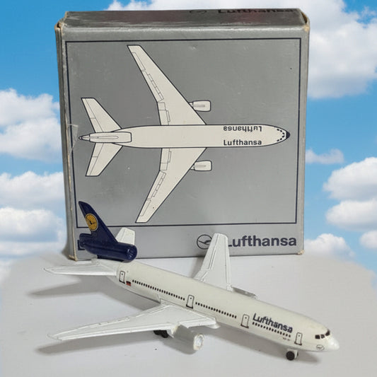 A small Lufthansa model airplane displayed next to its original box, which features a top-down illustration of the aircraft.