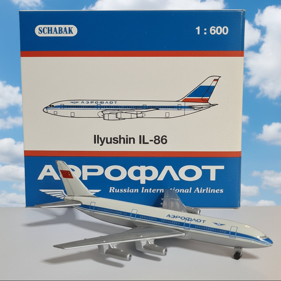 A 1:600 scale model airplane of an Ilyushin IL-86 operated by Aeroflot, shown next to its original blue and white packaging box by Schabak.