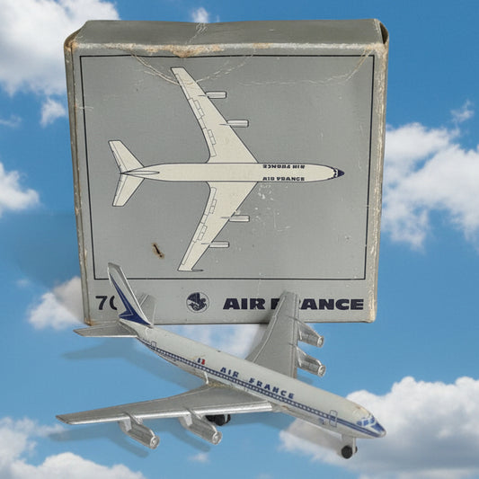 A small silver and blue model airplane placed beside its original box, which shows a top-down airplane drawing and the text 'AIR FRANCE'.