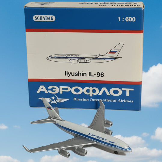 A 1:600 scale model airplane of an Ilyushin IL-96 Russian Airlines aircraft, shown next to its original box by Schabak. The model features a white fuselage with blue stripes and gray metallic wings and engines.