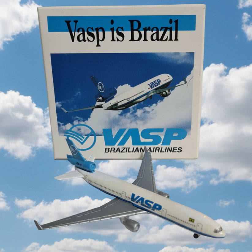 A small Vasp Brazilian Airlines model airplane displayed next to its printed box on a white shelf. The box features blue and white graphics with the text 'Vasp is Brazil' and 'Vasp BRAZILIAN AIRLINES'.