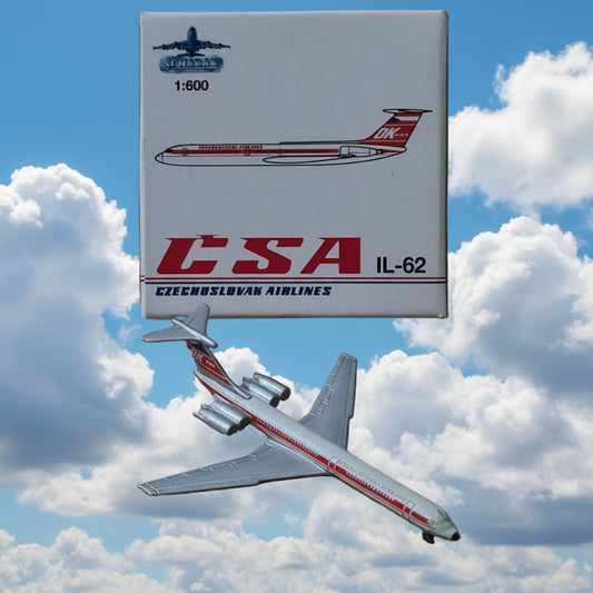 A small model airplane next to its retail box. The box is white with red and black graphics reading CESA IL-62 and Czech Airlines.